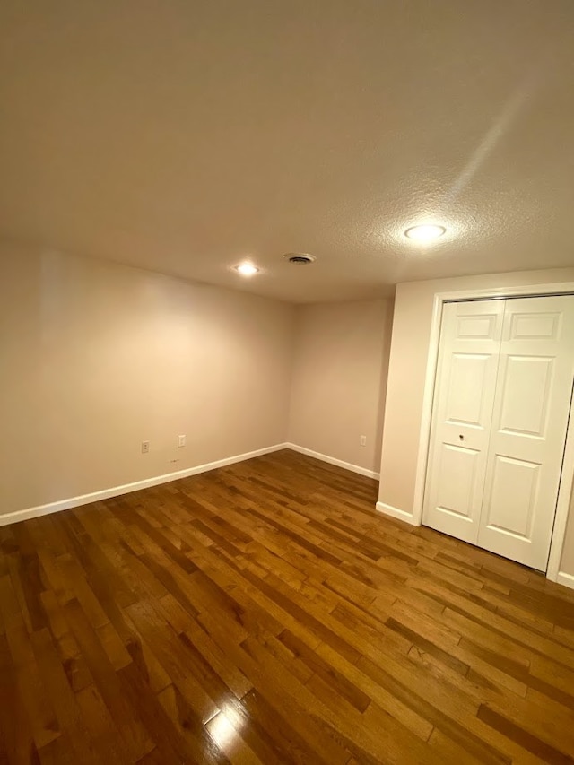 interior space featuring a textured ceiling and dark wood-type flooring