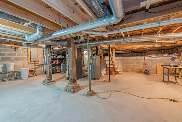 basement featuring electric panel and water heater