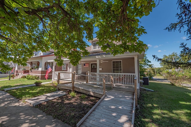 view of front of house with ceiling fan, a porch, and a front lawn