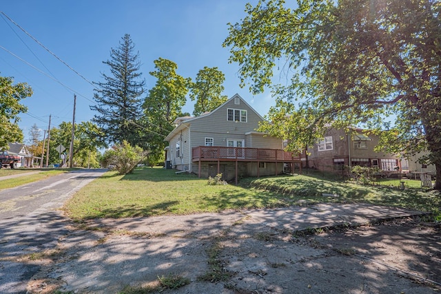 back of house featuring a wooden deck and a lawn