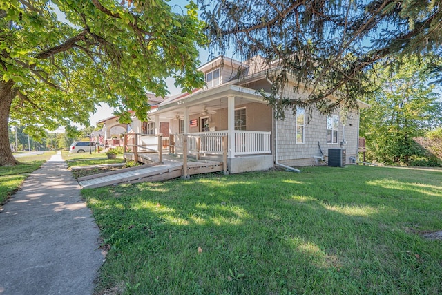 view of front of house with a front yard, central air condition unit, ceiling fan, and covered porch