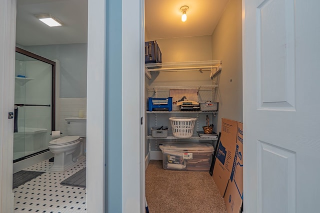 bathroom featuring toilet, an enclosed shower, baseboard heating, and tile walls