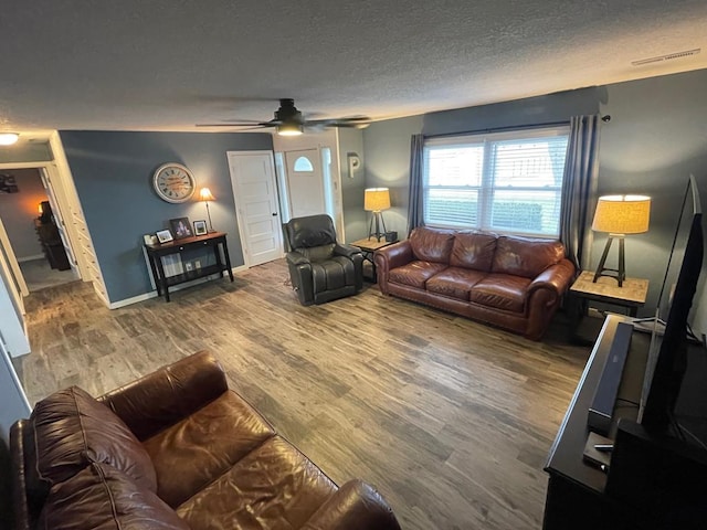 living room with wood-type flooring, a textured ceiling, and ceiling fan