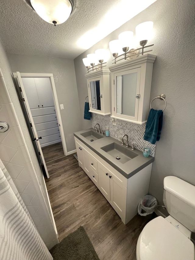 bathroom featuring vanity, hardwood / wood-style floors, a textured ceiling, and toilet