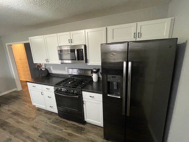 kitchen with white cabinetry, dark wood-type flooring, a textured ceiling, and appliances with stainless steel finishes