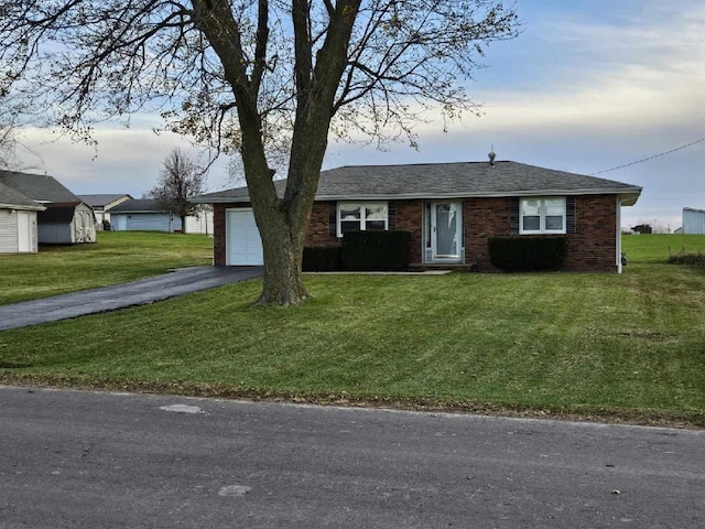 single story home featuring a front lawn and a garage