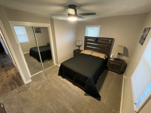 bedroom with carpet flooring, ceiling fan, a closet, and a textured ceiling