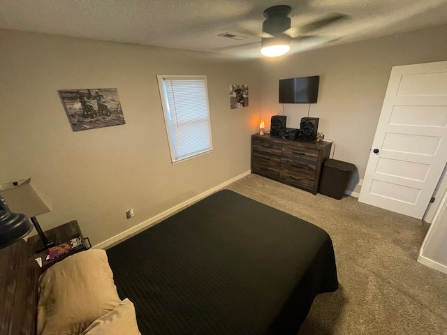 bedroom with a textured ceiling, carpet floors, and ceiling fan