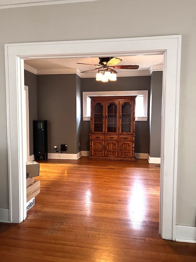 unfurnished living room featuring a wealth of natural light, crown molding, and hardwood / wood-style flooring