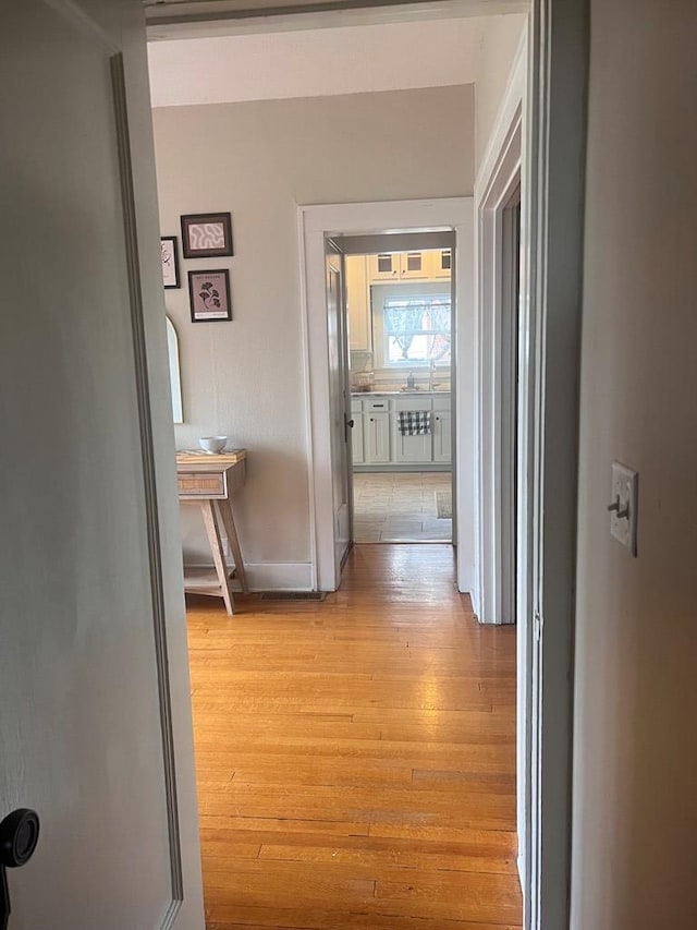 corridor with light hardwood / wood-style floors