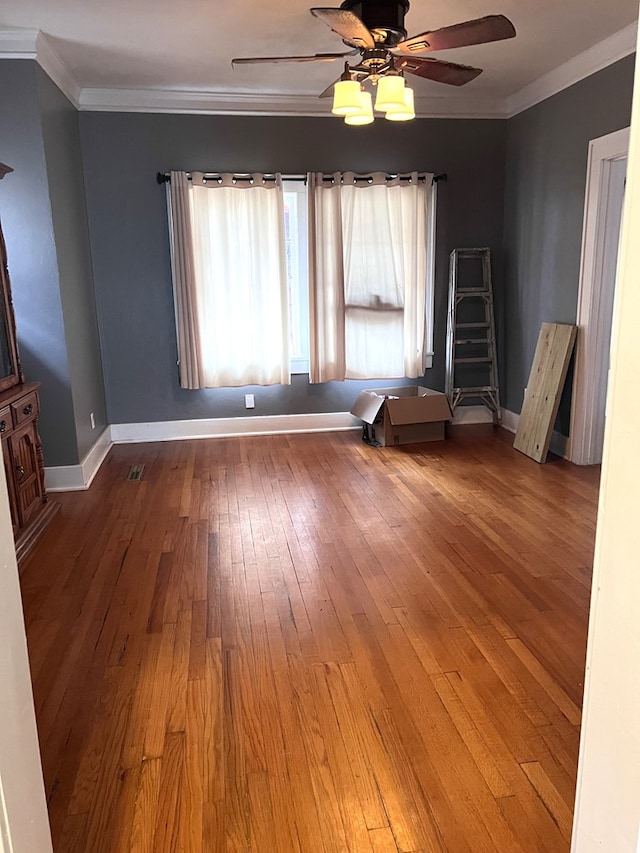 unfurnished room featuring hardwood / wood-style flooring, ceiling fan, and crown molding