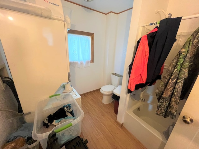 bathroom with wood-type flooring, bathtub / shower combination, and toilet