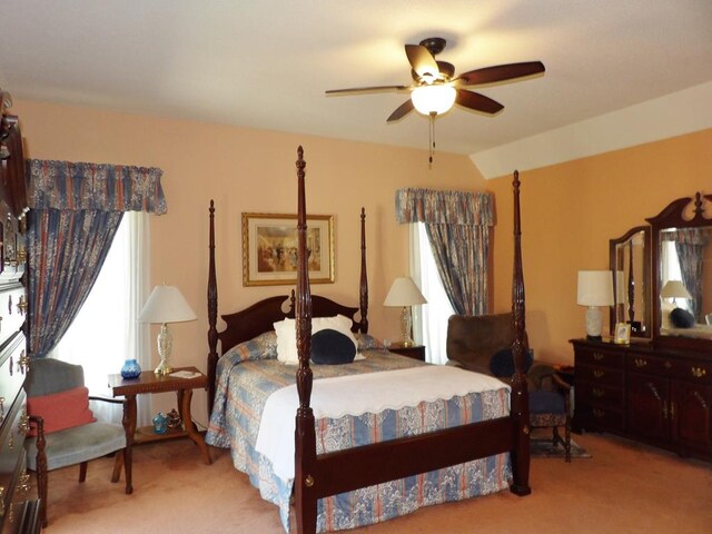 bedroom with ceiling fan, lofted ceiling, and light carpet