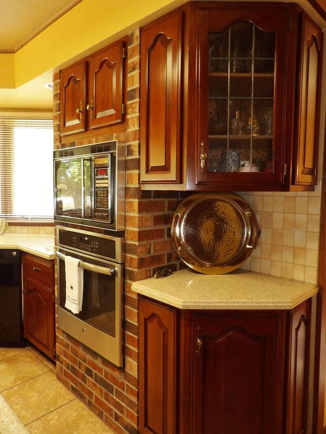 kitchen featuring black appliances, light tile patterned floors, and tasteful backsplash