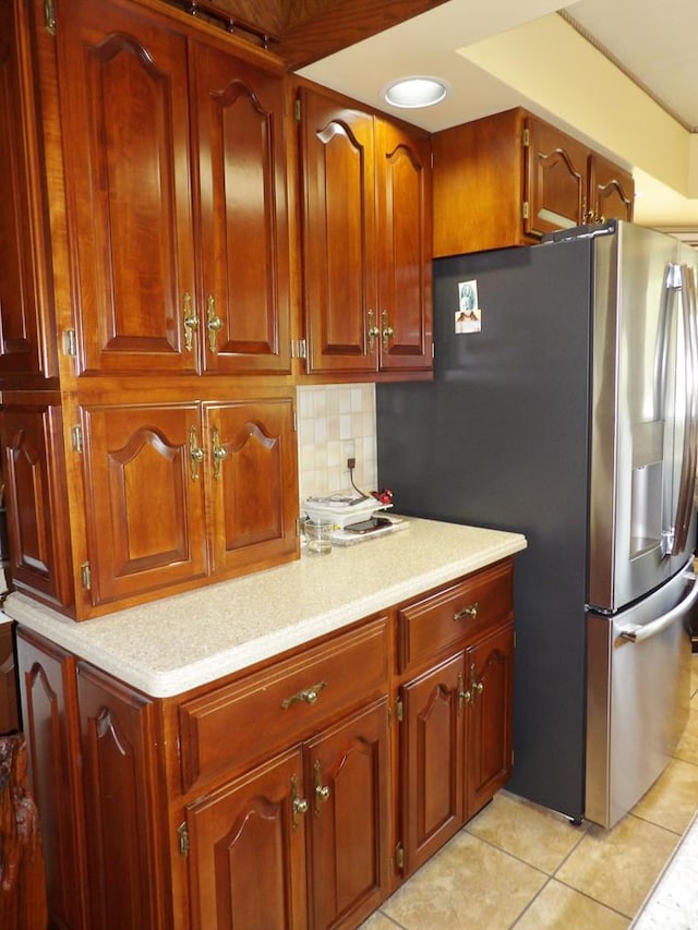 kitchen featuring tasteful backsplash, stainless steel fridge, and light tile patterned floors