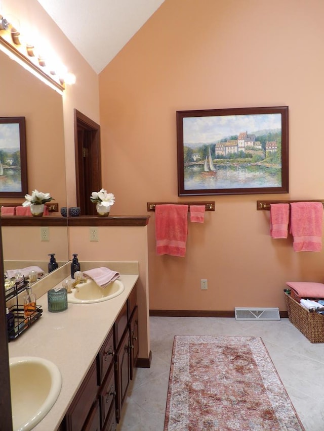 bathroom with tile patterned floors, vanity, and lofted ceiling