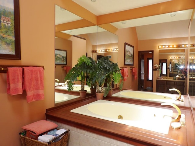 bathroom with vanity and tiled bath