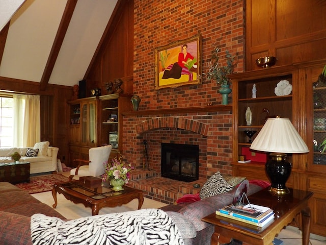 living room featuring beamed ceiling, high vaulted ceiling, a brick fireplace, and wooden walls