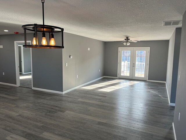 empty room featuring french doors, dark hardwood / wood-style flooring, a textured ceiling, and ceiling fan