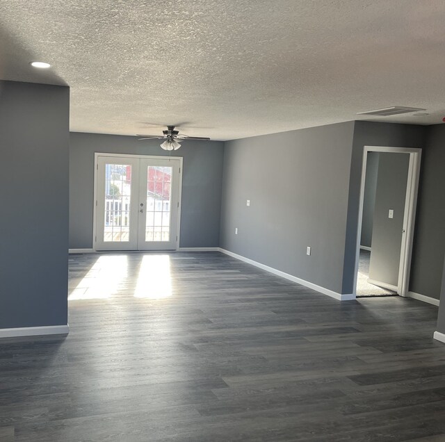 empty room with ceiling fan, french doors, a textured ceiling, and dark hardwood / wood-style floors