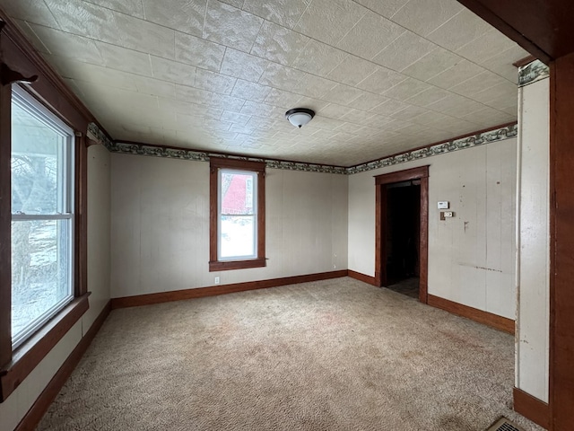 unfurnished room featuring carpet floors and baseboards