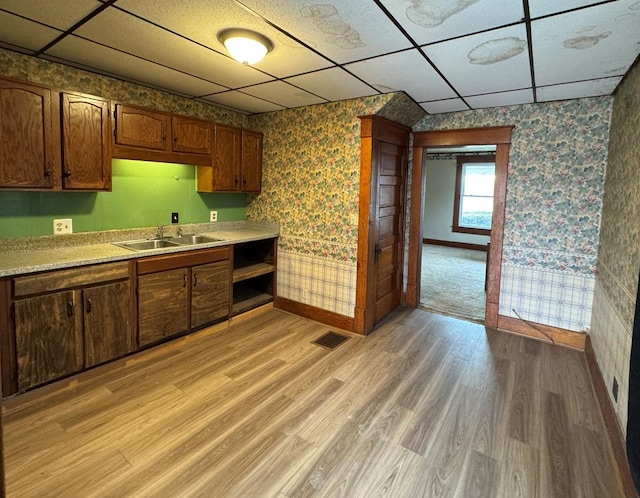 kitchen with a drop ceiling, visible vents, light countertops, light wood-type flooring, and wallpapered walls