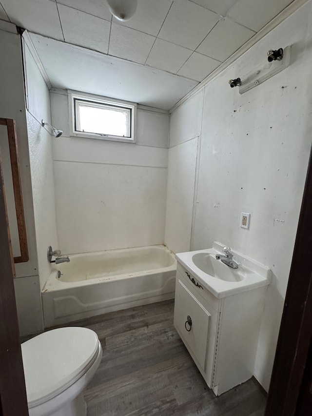 bathroom with toilet, shower / bathing tub combination, wood finished floors, and vanity