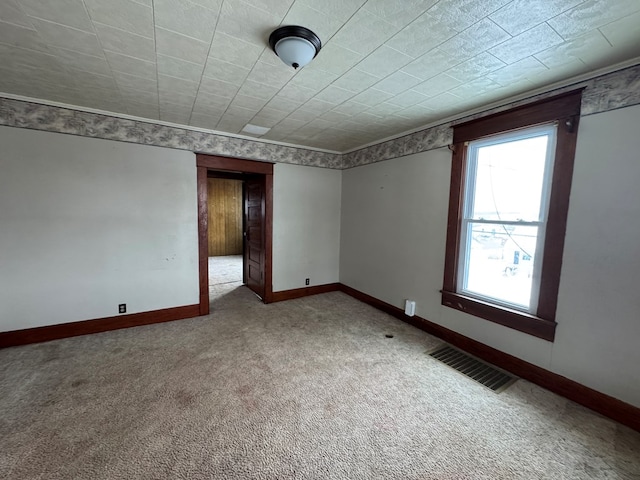 carpeted spare room with visible vents and baseboards