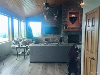 living room with wood-type flooring, vaulted ceiling, ceiling fan, and wood ceiling