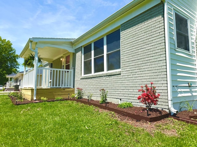713 E Dear St, Kirksville, MO 63501 - view of home's exterior with covered porch, brick siding, and a lawn