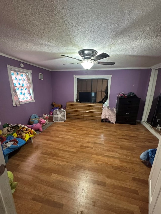 228 S Vine St, Milan, MO 63556 - unfurnished bedroom featuring a textured ceiling, wood finished floors, and ceiling fan
