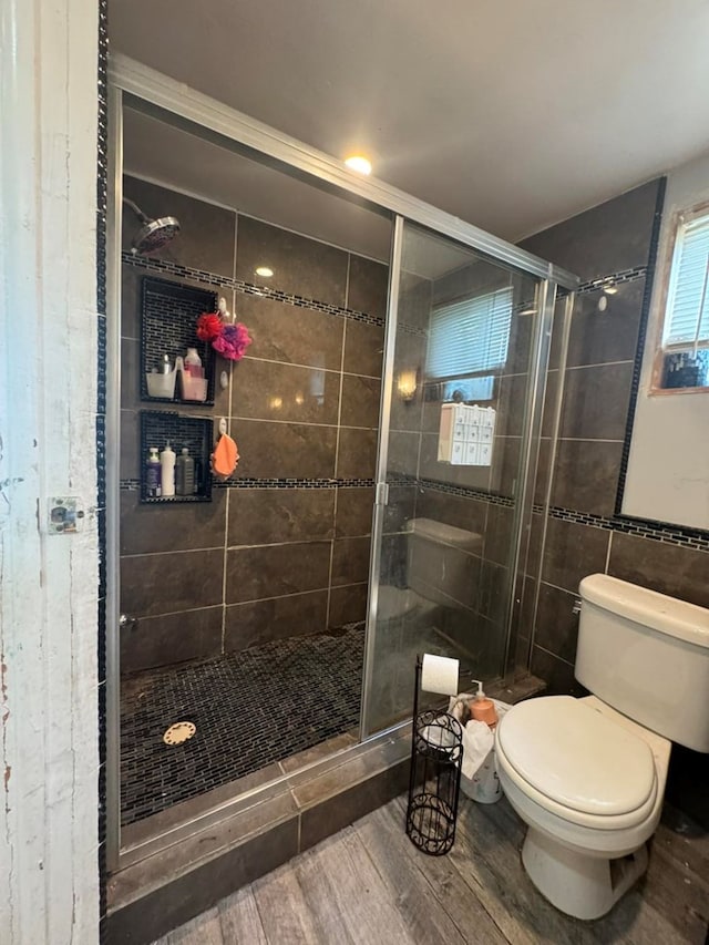 228 S Vine St, Milan, MO 63556 - full bath featuring wood finished floors, a shower stall, and tile walls