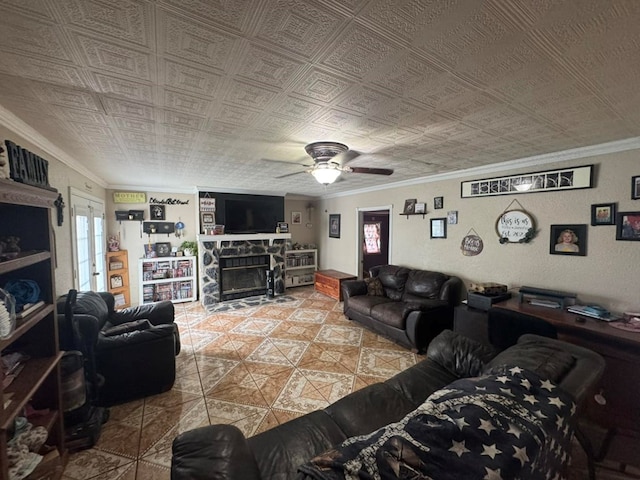 228 S Vine St, Milan, MO 63556 - living room featuring crown molding, tile patterned flooring, ceiling fan, and a stone fireplace