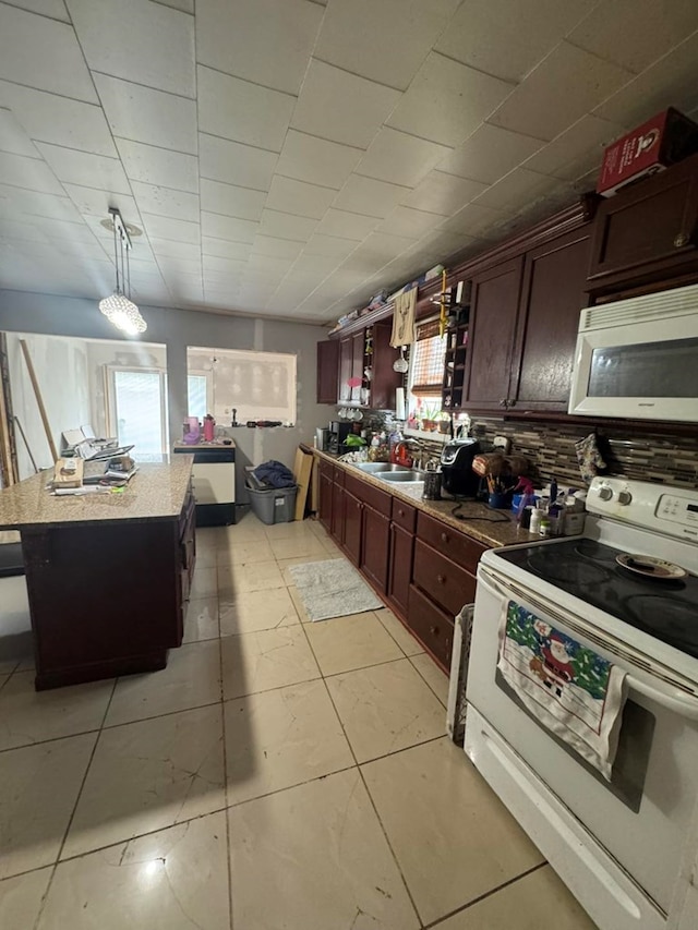228 S Vine St, Milan, MO 63556 - kitchen featuring white appliances, a kitchen island, and decorative light fixtures