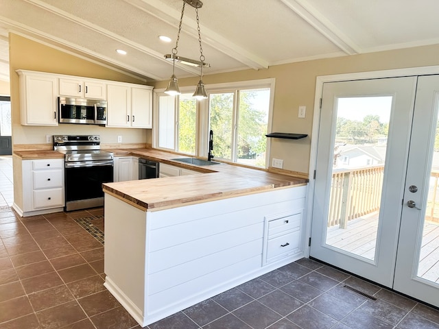 kitchen featuring sink, hanging light fixtures, butcher block countertops, white cabinetry, and stainless steel appliances