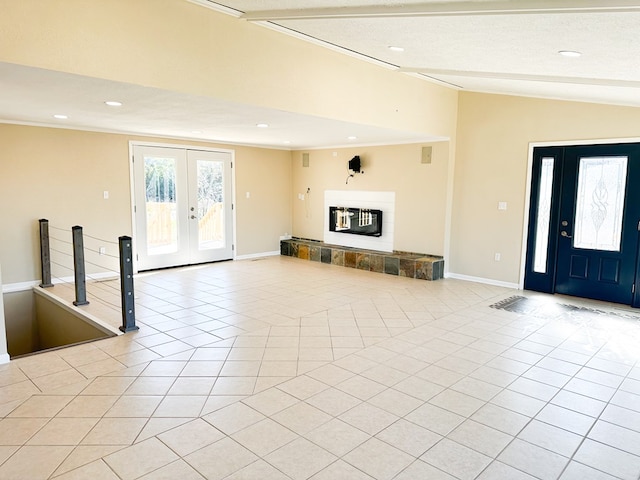 tiled entrance foyer with a fireplace, french doors, a textured ceiling, and lofted ceiling