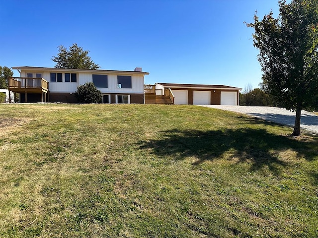 view of front of property with a garage, an outdoor structure, a wooden deck, and a front lawn