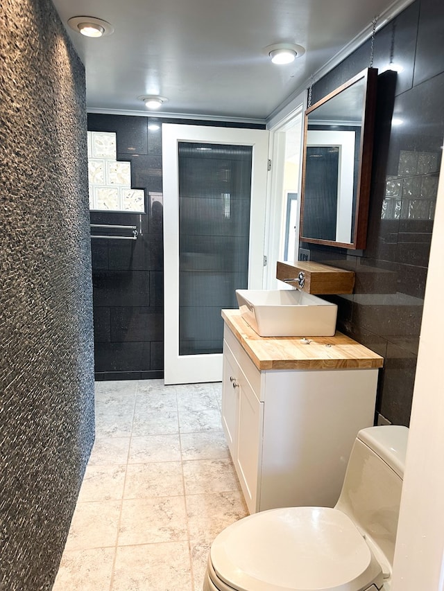 bathroom featuring vanity, toilet, and ornamental molding