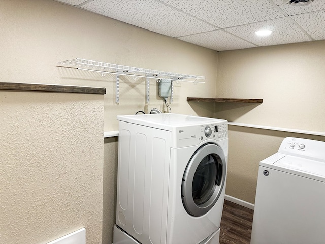 clothes washing area with washing machine and dryer and dark wood-type flooring