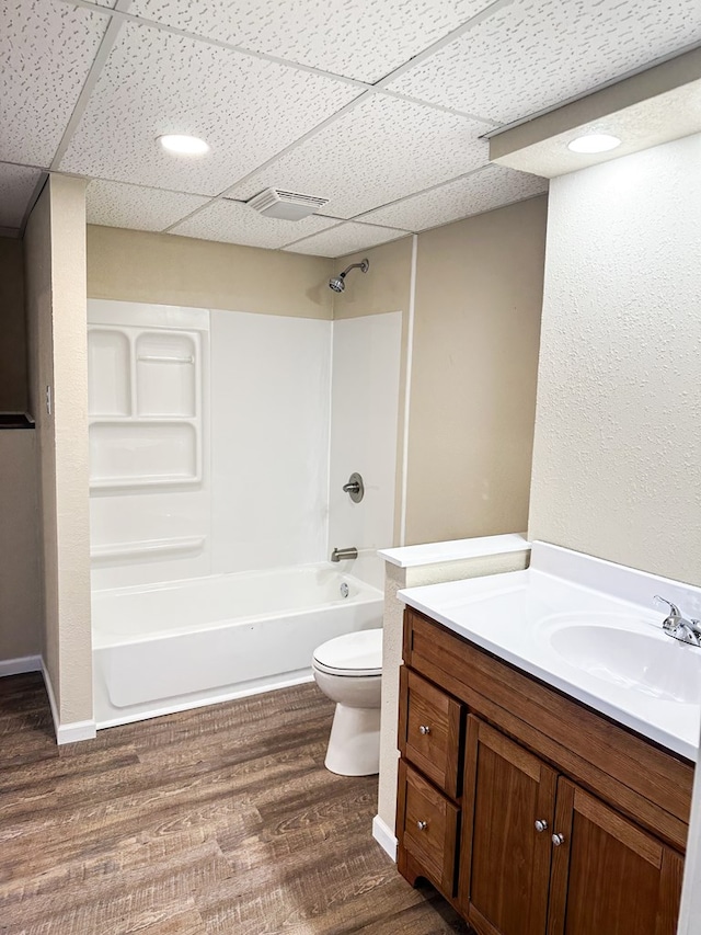 full bathroom featuring tub / shower combination, toilet, a paneled ceiling, vanity, and hardwood / wood-style flooring