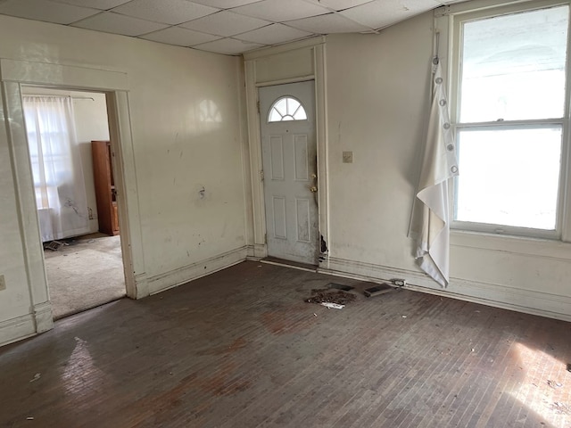 entryway featuring wood-type flooring, baseboards, and a drop ceiling