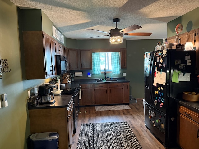 2515 N E St, Kirksville, MO 63501 - kitchen with a sink, black appliances, dark countertops, ceiling fan, and light wood finished floors