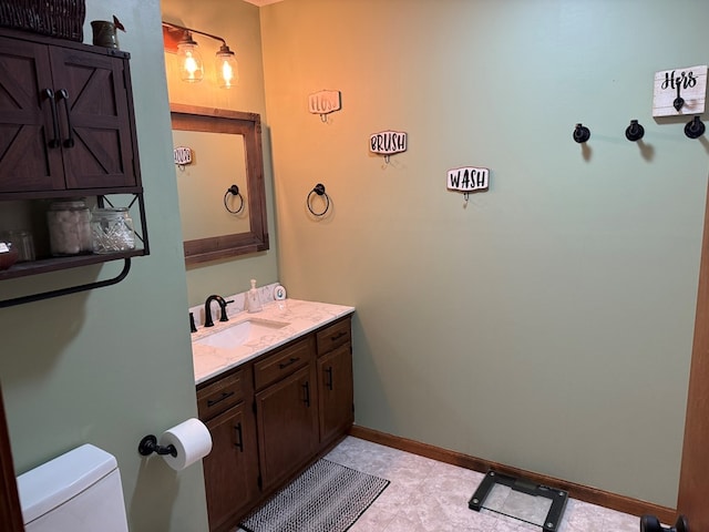 2515 N E St, Kirksville, MO 63501 - bathroom featuring toilet, vanity, and baseboards