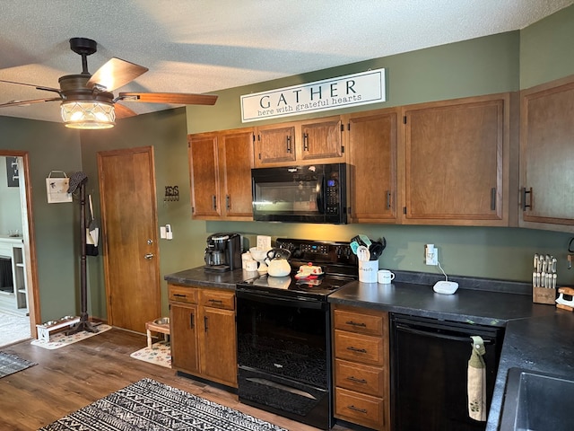 2515 N E St, Kirksville, MO 63501 - kitchen with black appliances, dark countertops, brown cabinetry, dark wood finished floors, and a textured ceiling