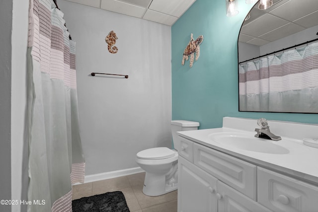 bathroom featuring tile patterned flooring, curtained shower, vanity, toilet, and a drop ceiling