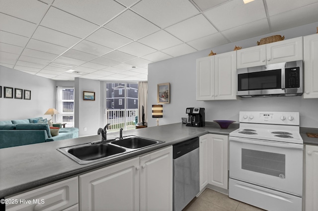 kitchen featuring a sink, light tile patterned floors, white cabinets, and stainless steel appliances