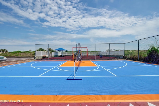 view of basketball court featuring community basketball court, fence, and playground community
