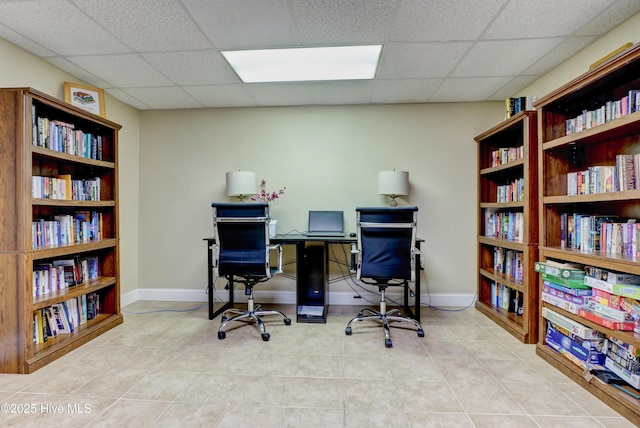 office space featuring baseboards, a paneled ceiling, and tile patterned floors