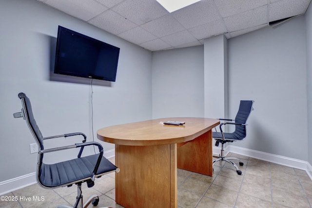 office area featuring baseboards, a paneled ceiling, and light tile patterned floors