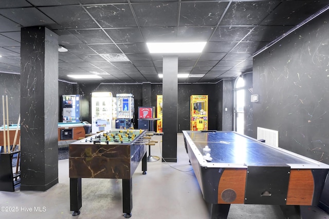 playroom featuring finished concrete flooring and a drop ceiling